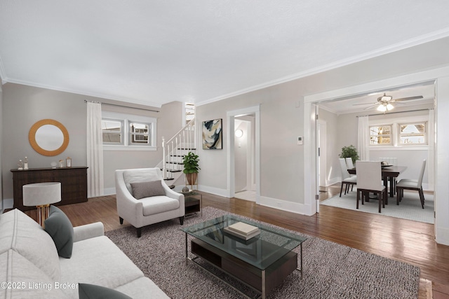 living room with hardwood / wood-style flooring, ceiling fan, and ornamental molding