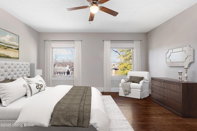 bedroom with multiple windows, dark hardwood / wood-style flooring, and ceiling fan