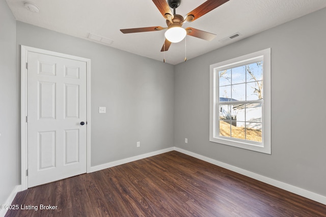 empty room with dark wood-type flooring and ceiling fan