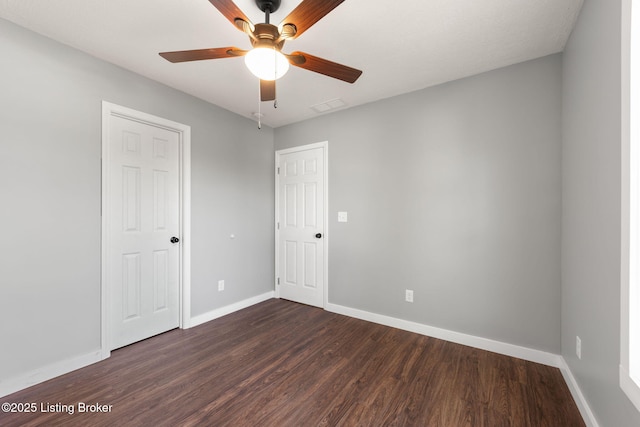 unfurnished room with dark hardwood / wood-style floors and ceiling fan