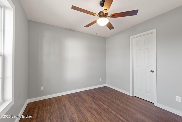 empty room with dark wood-type flooring and ceiling fan