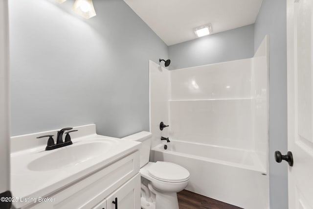 full bathroom with hardwood / wood-style flooring, vanity,  shower combination, and toilet