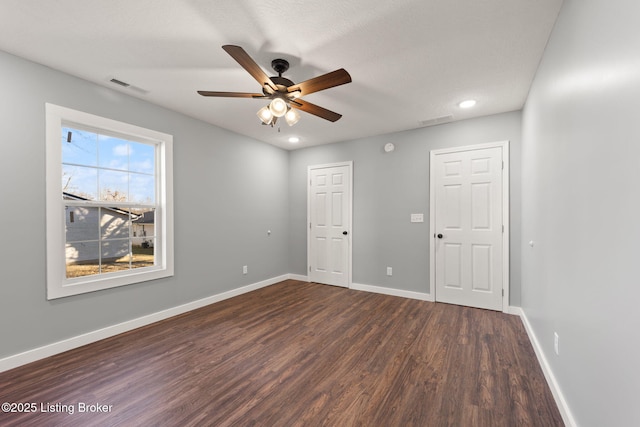 spare room featuring dark wood-type flooring and ceiling fan