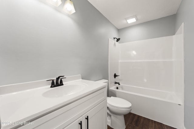 full bathroom featuring shower / washtub combination, hardwood / wood-style flooring, vanity, toilet, and a textured ceiling