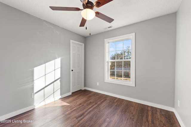 unfurnished room with dark wood-type flooring and ceiling fan