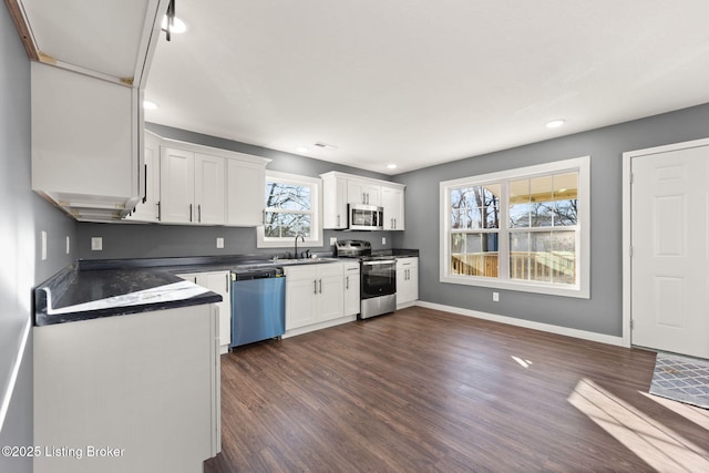 kitchen with white cabinetry, appliances with stainless steel finishes, sink, and dark wood-type flooring