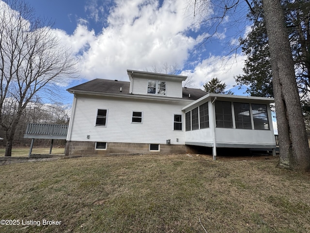 rear view of property with a sunroom and a lawn