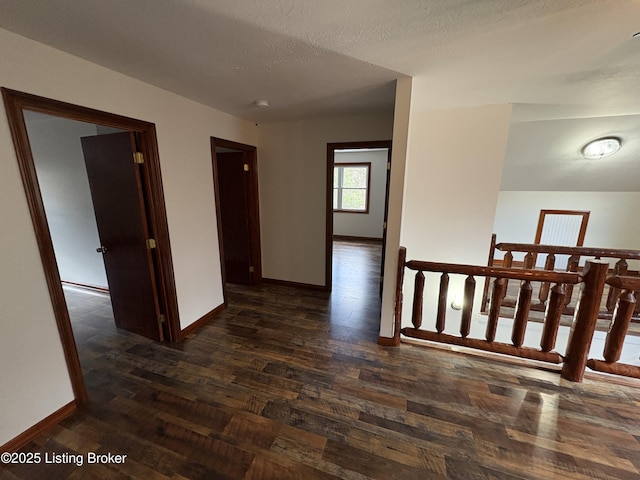 corridor with dark wood-type flooring and a textured ceiling