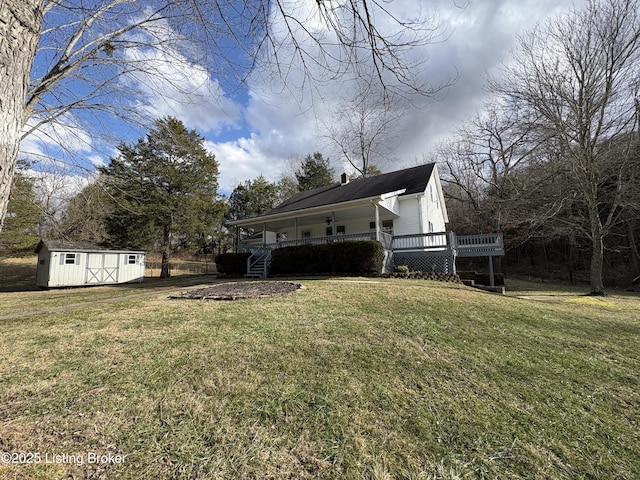 view of yard featuring a wooden deck and a storage unit