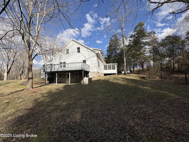 back of property with a yard, a sunroom, and a deck