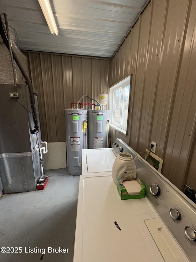 laundry area featuring washer and clothes dryer, electric water heater, and heating unit