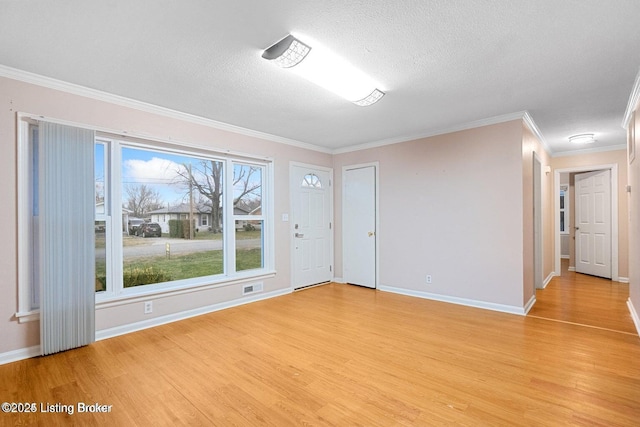 unfurnished room with crown molding, light hardwood / wood-style floors, and a textured ceiling