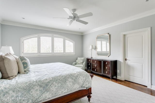 bedroom with wood-type flooring, ornamental molding, and ceiling fan