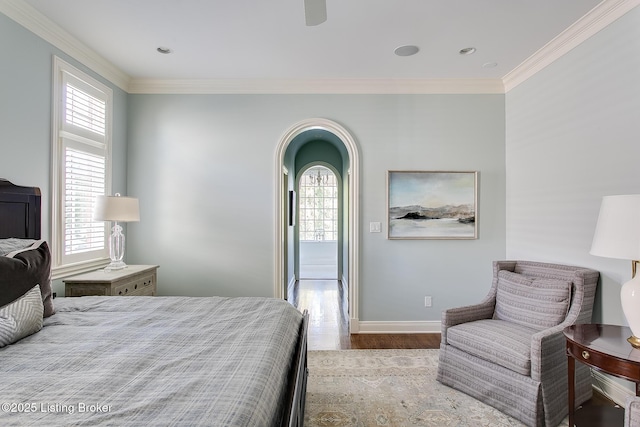 bedroom with crown molding, ceiling fan, and light hardwood / wood-style flooring