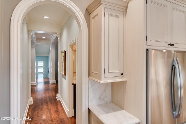 hallway with dark wood-type flooring and ornamental molding