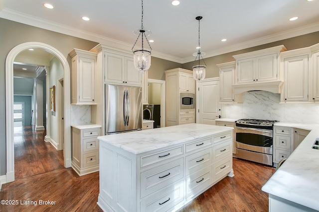 kitchen with pendant lighting, stainless steel appliances, a center island, and white cabinets