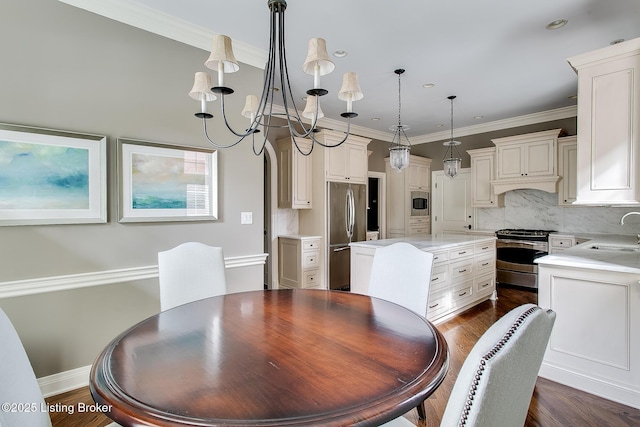 dining space featuring ornamental molding, a chandelier, and sink