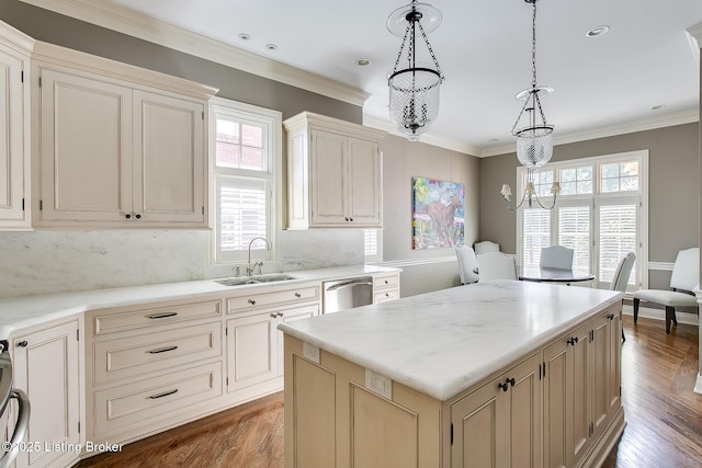 kitchen featuring crown molding, sink, decorative light fixtures, and a center island