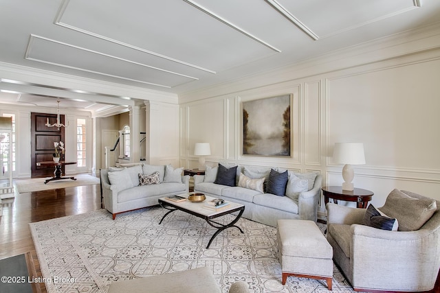 living room featuring ornate columns, ornamental molding, and light hardwood / wood-style floors