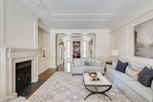 living room with crown molding, dark hardwood / wood-style floors, and ornate columns