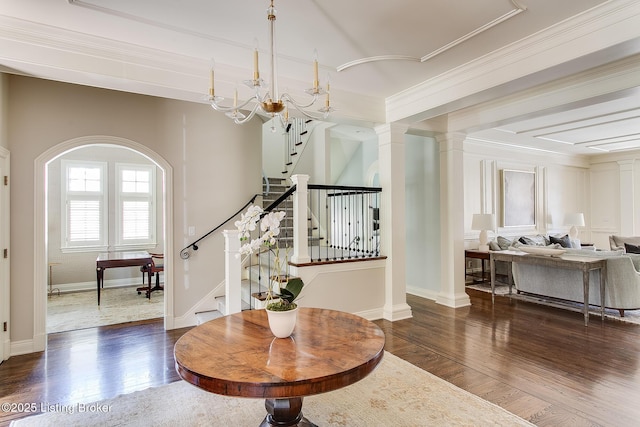 foyer with ornamental molding, dark hardwood / wood-style floors, and ornate columns