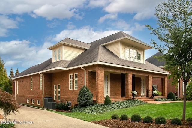 view of front of home featuring a porch, a front yard, and central AC unit