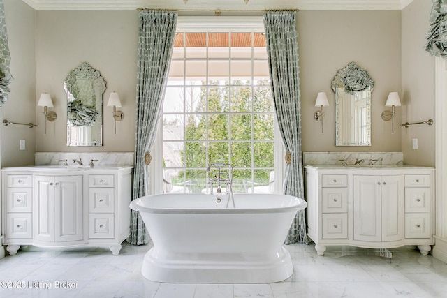 bathroom featuring vanity, a tub to relax in, crown molding, and plenty of natural light