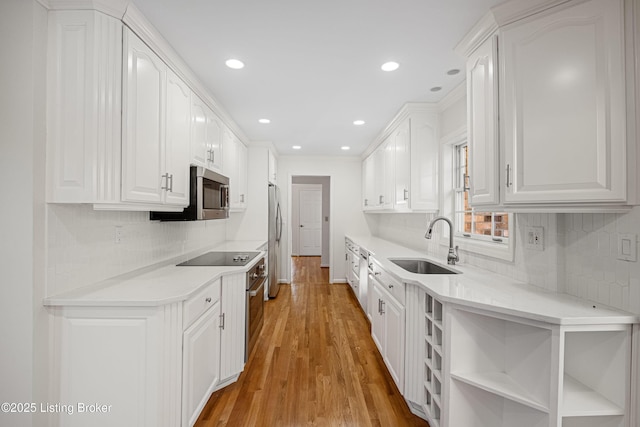 kitchen with white cabinetry, appliances with stainless steel finishes, sink, and light hardwood / wood-style floors