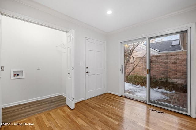 doorway featuring ornamental molding and light wood-type flooring