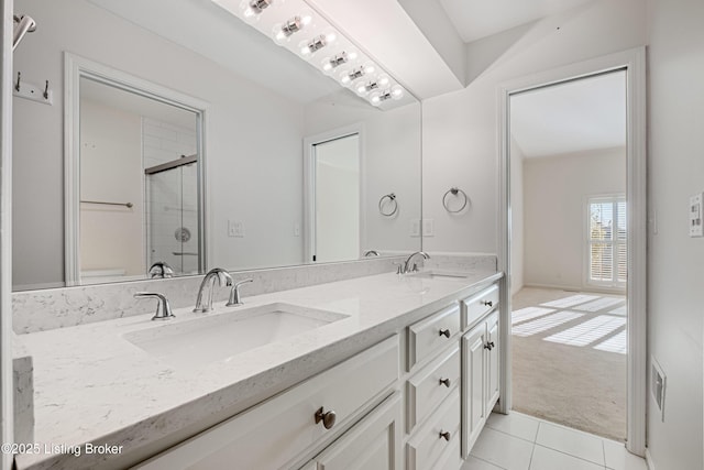 bathroom featuring tile patterned floors, vanity, and a shower with door