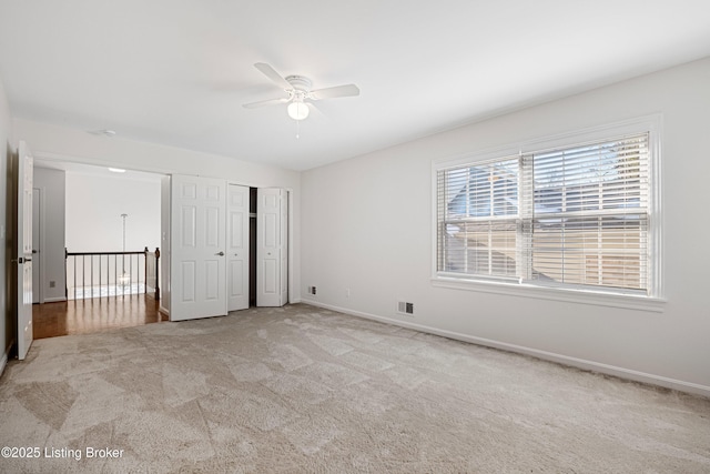 unfurnished bedroom with light carpet, a closet, and ceiling fan