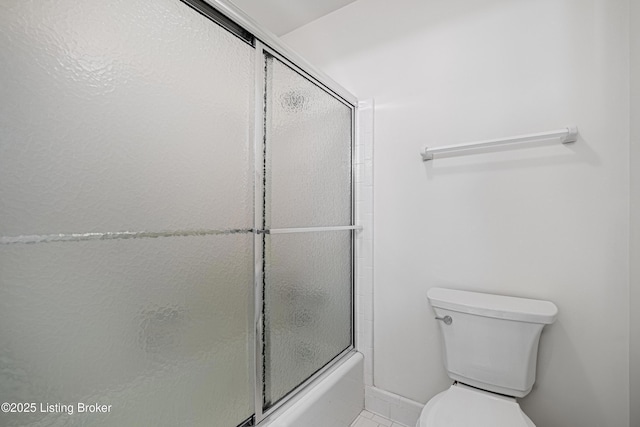 bathroom with enclosed tub / shower combo and toilet