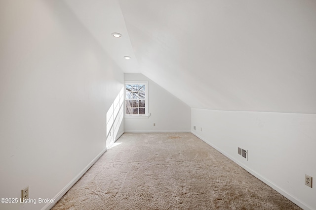 additional living space with lofted ceiling and light carpet