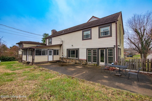 back of property with a yard, a patio area, and a sunroom