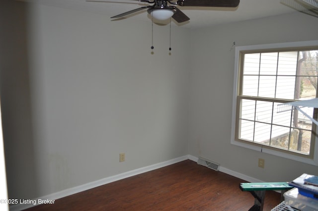 empty room with ceiling fan, dark wood-type flooring, and a healthy amount of sunlight