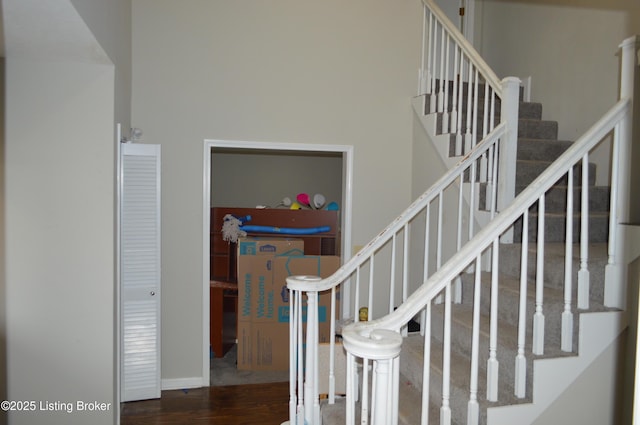 stairway featuring hardwood / wood-style flooring and a towering ceiling