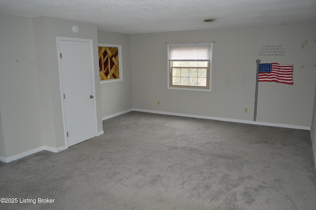 carpeted spare room with a textured ceiling