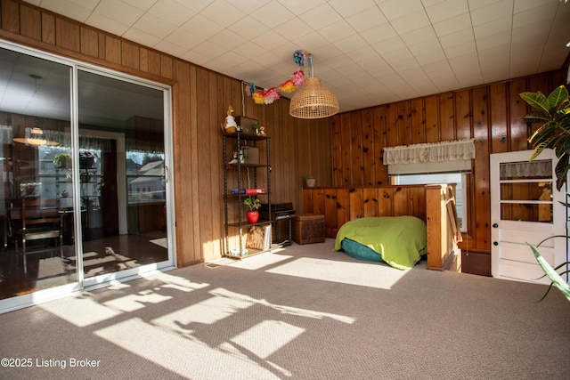 bedroom featuring carpet floors and wooden walls