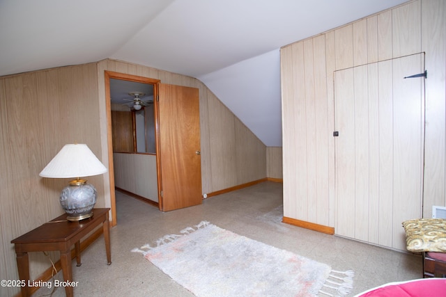 additional living space with vaulted ceiling and wood walls