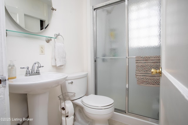 bathroom with a shower with shower door and toilet