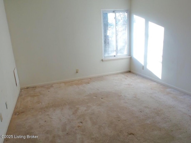 empty room featuring carpet flooring and baseboards