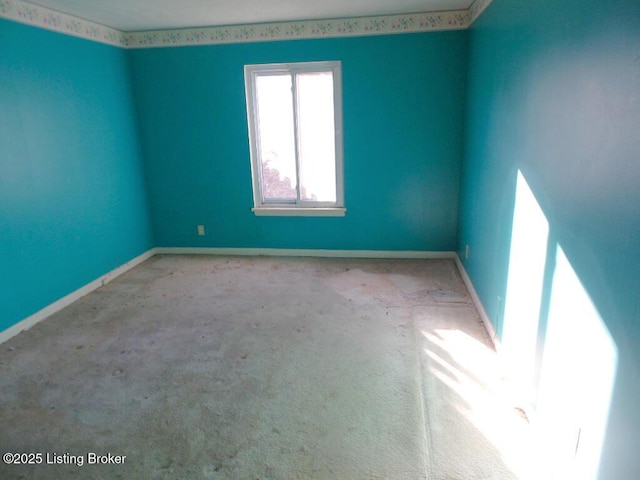 carpeted empty room with baseboards