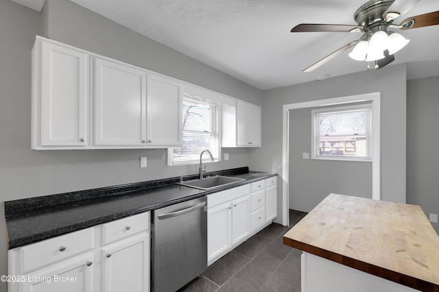 kitchen featuring white cabinetry, sink, wooden counters, stainless steel dishwasher, and ceiling fan