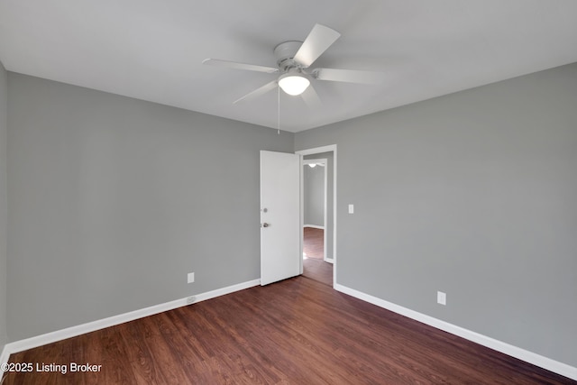 spare room with dark hardwood / wood-style flooring and ceiling fan