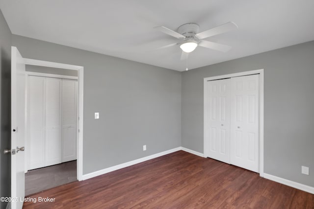 unfurnished bedroom featuring a closet, dark hardwood / wood-style floors, and ceiling fan