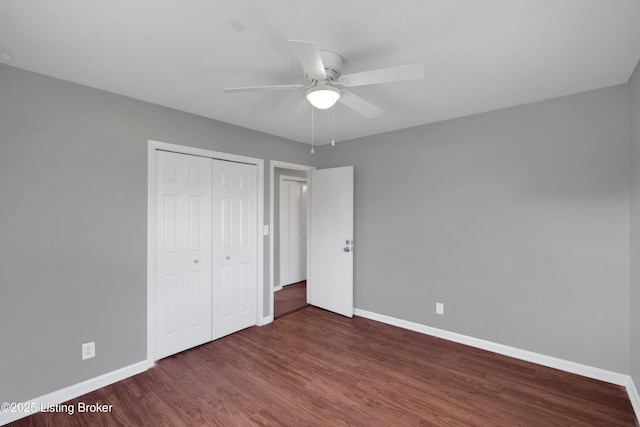 unfurnished bedroom with ceiling fan, dark hardwood / wood-style flooring, and a closet