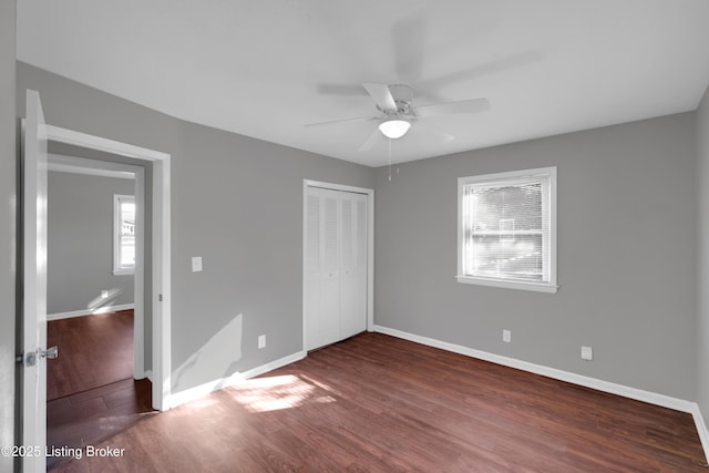 unfurnished bedroom with ceiling fan, dark hardwood / wood-style floors, and a closet