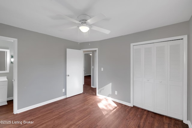 unfurnished bedroom featuring dark hardwood / wood-style floors, ceiling fan, and a closet