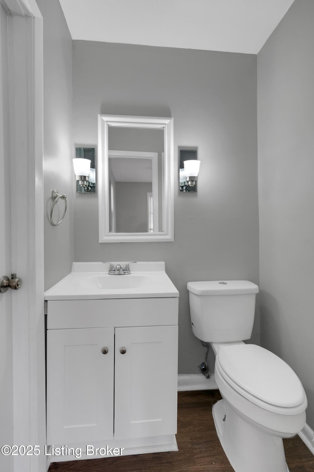 bathroom featuring vanity, hardwood / wood-style floors, and toilet