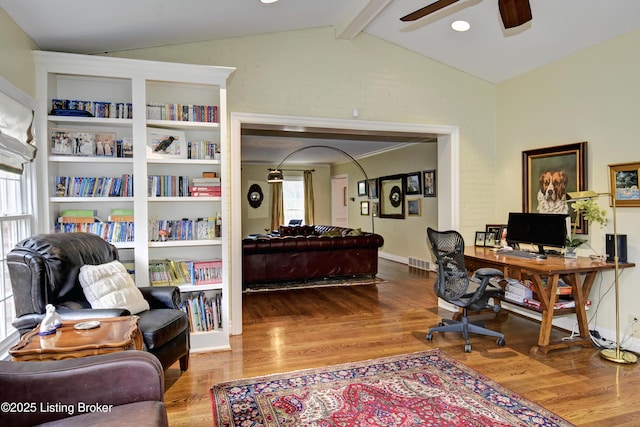 home office featuring lofted ceiling with beams, hardwood / wood-style flooring, and ceiling fan